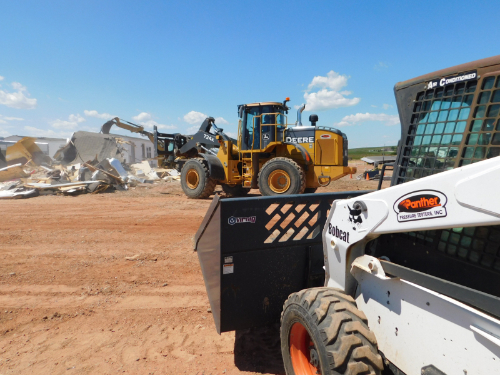 Panther Loader in foreground with other machinery in background doing tear-down.